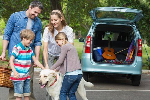 Familj tar med sin hund på utflykt.